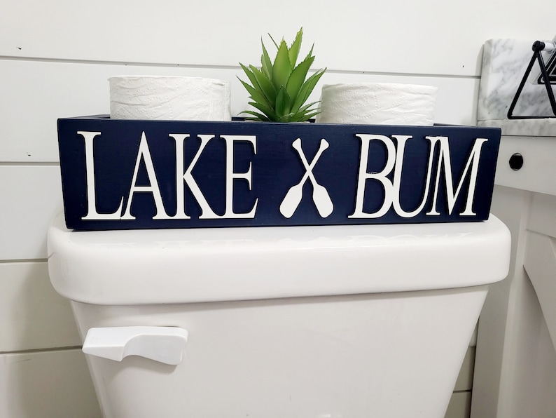 May include: A rustic wooden sign with the text "Welcome to our home" in white lettering. The sign features a distressed finish and a simple, inviting design, perfect for a front porch or entryway.