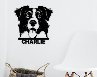 May include: Black and white metal wall art featuring a dog's face with the name "CHARLIE" below. The dog's face is detailed with open eyes and a tongue sticking out. The art is mounted on a white wall.