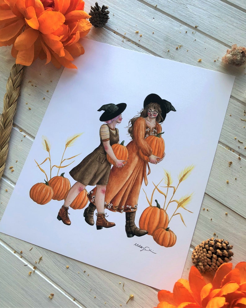 May include: Two witches in black hats and fall-themed outfits carry pumpkins in a field of wheat. The witches are wearing brown boots and have long brown hair. The pumpkins are orange and round. The background is a white canvas.