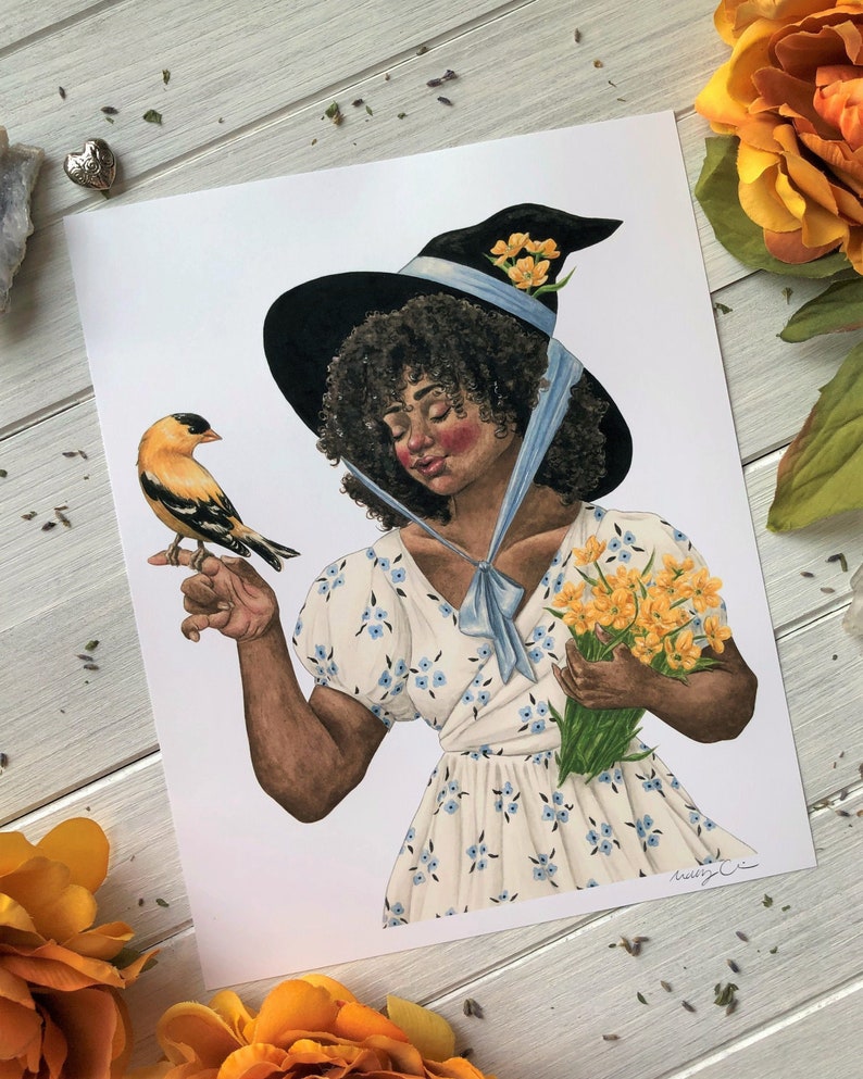 May include: A watercolor illustration of a woman with dark curly hair wearing a black witch hat with a blue ribbon and a white dress with blue flowers. She is holding a bouquet of yellow flowers and a small yellow bird is perched on her finger.
