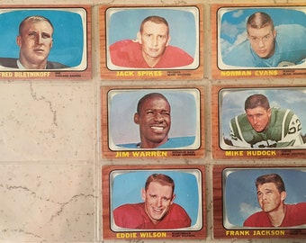 May include: A collection of vintage football trading cards featuring players like Fred Biletnikoff, Jack Spikes, and Norman Evans. Each card has a portrait of a player with their name and team information, set within a decorative frame.