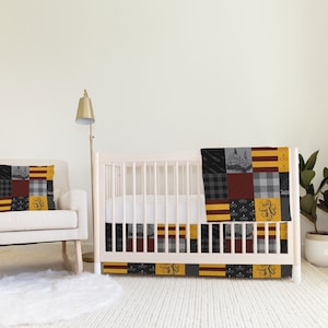 May include: A nursery crib bedding set with a patchwork design featuring the Hogwarts house crests and other Harry Potter themed elements. The set includes a crib skirt, a quilt, and a pillow. The colors are black, red, yellow, and gray.