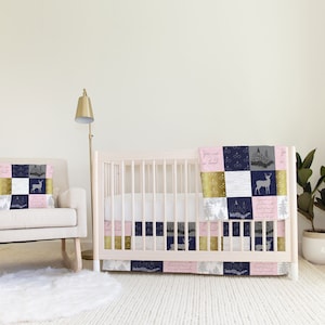 May include: A white crib with a pink and blue patchwork quilt and a matching pillow. The crib is in a nursery with a white rocking chair and a gold floor lamp.