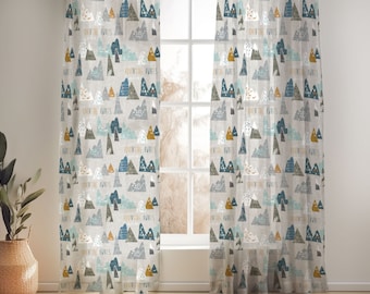 May include: A pair of sheer curtains with a light gray background and a repeating pattern of blue, green, and yellow mountains. The mountains have a textured look and the text "Adventure Awaits" is repeated throughout the pattern.