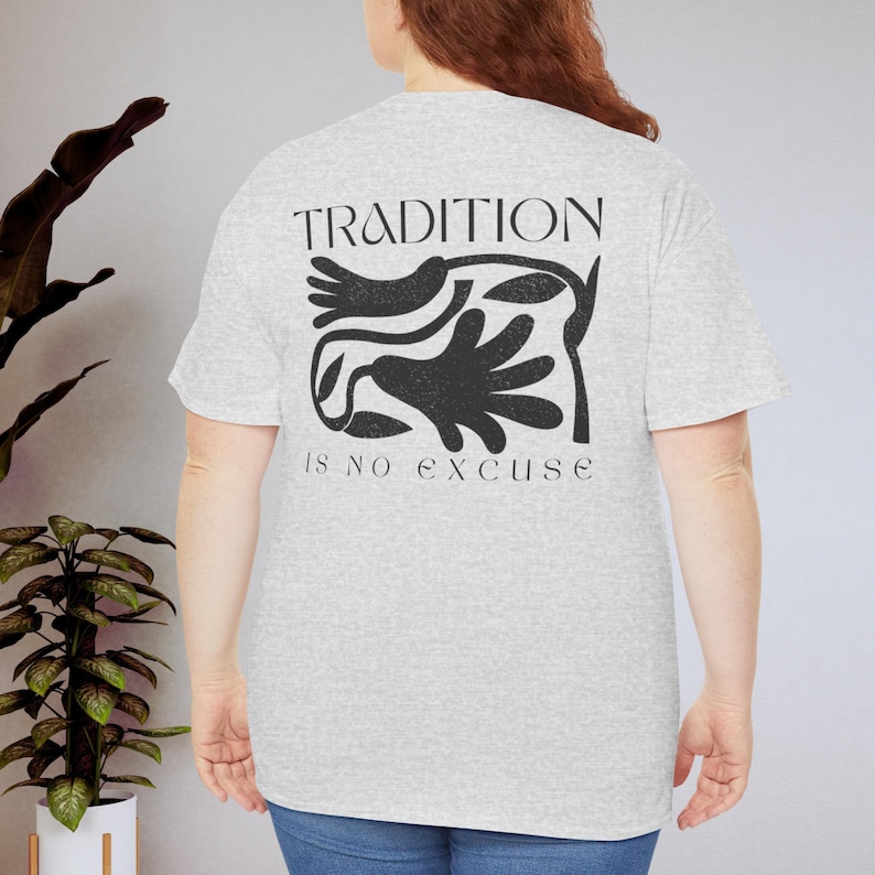 Może przedstawiać: Jasnoszara koszulka z czarnym napisem "TRADITION is no excuse". Koszulka posiada czarny graficzny wz&oacute;r z abstrakcyjnych kształt&oacute;w. Koszulka wykonana jest z miękkiego materiału i ma kr&oacute;tkie rękawy.