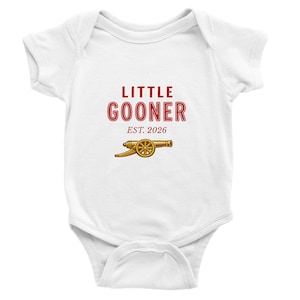 Könnte beinhalten: Weißer Baby-Body mit rotem Schriftzug "LITTLE GOONER EST. 2026" und einer goldenen Kanonen-Grafik. Der Body ist ein einteiliges Kleidungsstück für Babys.