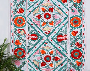 May include: White cotton tapestry with a geometric design featuring colourful embroidered flowers and pomegranates. The design is in shades of red, orange, green, and pink.