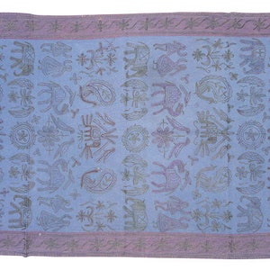 May include: A blue and purple patterned throw blanket with a repeating design of stylised animals and flowers. The blanket has a fringed edge.