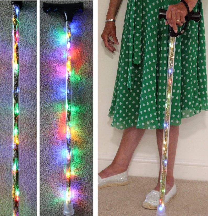May include: A clear walking cane with embedded colorful LED lights. The cane has a black handle and a clear tip. The lights are visible along the entire length of the cane, creating a decorative and functional mobility aid.