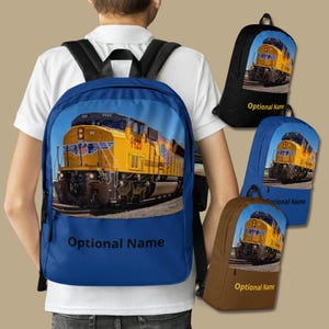 May include: Blue backpack with a yellow and black train on the front. The train is a Union Pacific locomotive with the number 9920 on the side. The backpack has the text "Optional Name" on the bottom.