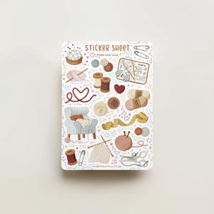 May include: A sticker sheet featuring illustrations of craft-related items. The design includes balls of yarn, buttons, scissors, a knitting project, and a heart-shaped yarn design. The text "STICKER SHEET" and "made with love" are visible.