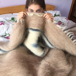 May include: A person is partially hidden under a fluffy, brown and white striped blanket. The blanket has a soft, fuzzy texture.