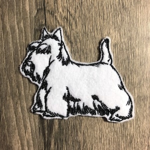 Op de afbeelding: Witte geborduurde patch van een Schotse Terriër met een zwarte omtrek.