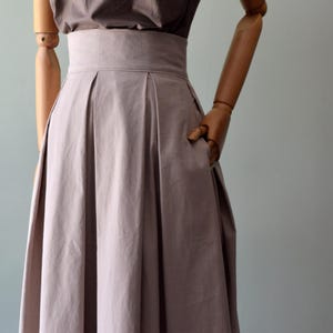 SCIROCCO, sand colour skirt in Oxford fabric. Pleated skirt in sand color pure cotton. With beige cotton voile band