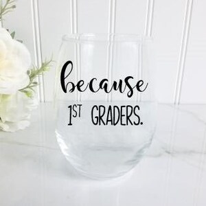 May include: A clear glass wine glass with the text "because 1st graders." printed on it.