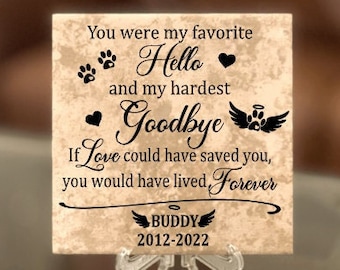 May include: A beige ceramic tile with black text that reads "You were my favorite Hello and my hardest Goodbye If Love could have saved you, you would have lived Forever BUDDY 2012-2022". The tile has a paw print design and a heart.