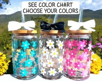 May include: Three glass jars with wooden lids, decorated with flower decals and bows. One jar has turquoise flowers, another white, and the third pink. The text "SEE COLOR CHART CHOOSE YOUR COLORS" is displayed above the jars.
