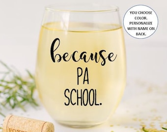 Puede incluir: Una copa de vino de vidrio transparente con el texto "because PA SCHOOL." impreso en la parte delantera. La copa está llena de un líquido amarillo claro.