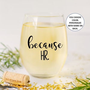 May include: A clear glass wine glass with the text "because HR." printed on the front. The glass is filled with white wine. You can choose the color and personalize with a name on the back.
