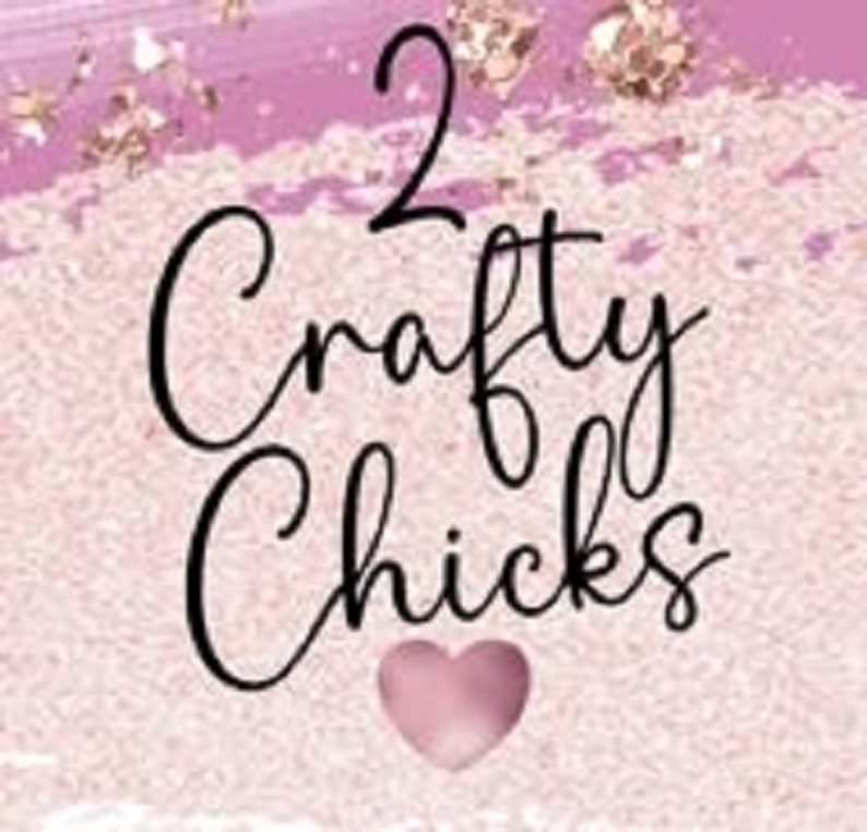May include: A pink and gold background with the text "2 Crafty Chicks" in black cursive font. A pink heart is below the text.