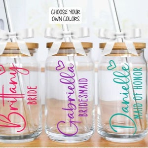 May include: Three glass jars with bamboo lids and straws. Each jar has a different name and title: "Brittany Bride", "Gabriella Bridesmaid", and "Danielle Maid of Honour".