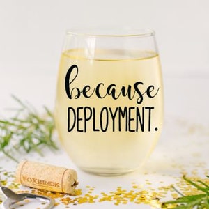 Pu&ograve; includere: Un bicchiere di vino in vetro trasparente con vino bianco al suo interno. Il bicchiere ha un adesivo in vinile nero che dice "because deployment."