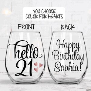 May include: Two stemless wine glasses with black script. One glass says "hello 21" with three pink hearts. The other says "Happy Birthday Sophia!" The text "You choose color for hearts" is above the glasses.