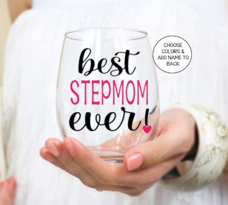 May include: A clear glass wine glass with the text "best stepmom ever!" in black and pink lettering. A small pink heart is next to the exclamation point.