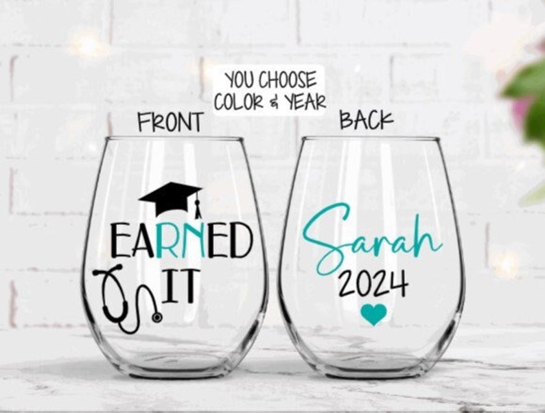 May include: Two clear wine glasses with a teal design. The front glass has a graduation cap, stethoscope, and the text "Earned It". The back glass has the name "Sarah" and the year "2024".