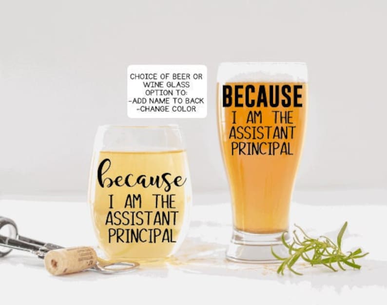 May include: Two wine glasses with the text "because I am the assistant principal" printed on them. The glasses are filled with a light yellow liquid.