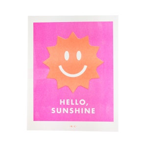 Peut inclure: Une impression rose et orange avec un soleil souriant et le texte "HELLO, SUNSHINE" avec les initiales "N.C." en bas.