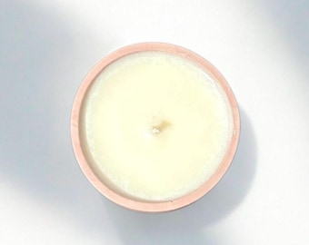 Vela de soja perfumada artesanal en recipiente hecho a mano
