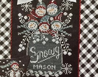May include: Two cross-stitch patterns featuring snowmen. The larger pattern shows a mason jar filled with snowmen and the text "Snowy Mason". The smaller pattern shows two snowmen with the text "Snowy".