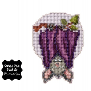 May include: Cross stitch pattern of a purple bat with a cute face, hanging upside down from a branch. The bat is surrounded by a white circle.