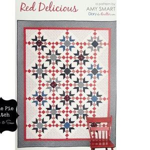 May include: A quilt pattern titled "Red Delicious" by Amy Smart, featuring a red, white and blue star design. The pattern is from Diary of a Quilter.com.