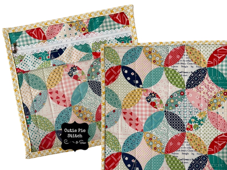 May include: A quilted fabric pouch with a zipper closure and a white lace trim. The pouch is decorated with a patchwork design of colorful circles and the text "Cutie Pie Stitch".