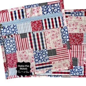 May include: A patchwork zippered pouch and a smaller matching item. The design features red, white, and blue fabrics with floral, flag, and paisley patterns. The pouch has a light blue zipper and trim. The label reads "Cutie Pie Stitch & Sew."