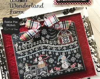 May include: A cross-stitch design titled "Winter Wonderland Farm" featuring a black background with snowflakes, snowmen, and a red barn. The design includes a truck, chickens, and the text "Winter Wonderland Farm". A smaller sign reads "Winter's Wonderland Farm".