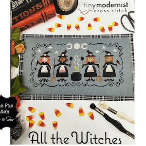 Puede incluir: Patrón de punto de cruz con cuatro brujas con sombreros y vestidos negros, un caldero, escobas y estrellas. El patrón se titula "All the Witches" y es de la tienda Cutie Pie Stitch & Sew.