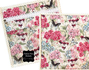 Bolsa para proyectos hecha a mano con tela acolchada con estampado floral de mariposas, ventana de vinilo y cremallera decorativa.