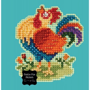 May include: A colorful beaded rooster with a red comb and a blue, green, and purple tail. The rooster is standing on a green patch of grass with a small orange flower.