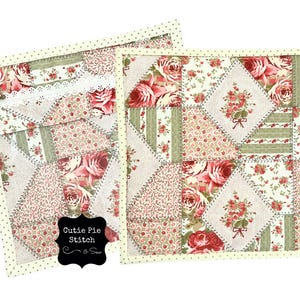 May include: Two cream-colored fabric squares with a white dotted border. Each square is made of a patchwork of different floral fabrics in shades of pink, red, and green. The squares are sewn together with a decorative stitch. The text "Cutie Pie Stitch & Sew" is written on a black chalkboard label.