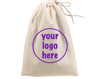Op de afbeelding: Een witte katoenen trekkoordtas met een paarse cirkel en de tekst "your logo here" erop gedrukt.