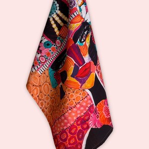 Pu&ograve; includere: Un asciugamano da cucina colorato con un ritratto stilizzato del viso di una donna. Il design presenta colori vivaci come arancione, rosa, rosso e giallo, con accenti neri. L'asciugamano &egrave; realizzato in cotone ed &egrave; perfetto per asciugare piatti o mani.