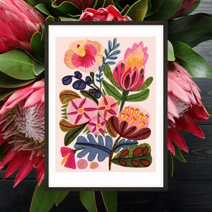 Pode incluir: Uma impress&atilde;o emoldurada de uma ilustra&ccedil;&atilde;o floral colorida com flores rosa, vermelhas, amarelas, verdes e azuis sobre um fundo rosa.