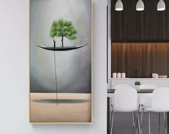 May include: A vertical rectangular wall art piece in a gold frame depicting a surreal scene with a small black boat floating in a gray sky. A single green tree grows from the boat, and a thin black line extends downward to a tan ground surface.