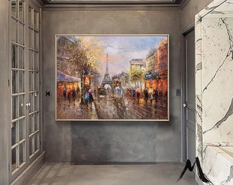 May include: A rectangular oil painting in a light wood frame depicting a Parisian street scene with the Eiffel Tower in the distance. The artwork features warm orange and yellow tones, cool blue shadows, and textured brushstrokes of people walking.