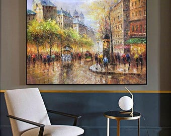 May include: A rectangular oil painting on canvas depicting a bustling European city street scene with tall buildings, lush green trees, and a horse-drawn carriage. The artwork features a vibrant colour palette of yellows, greens, and browns.
