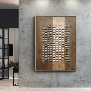May include: A brown rectangular canvas with a grid of white squares. The canvas is hanging on a concrete wall.