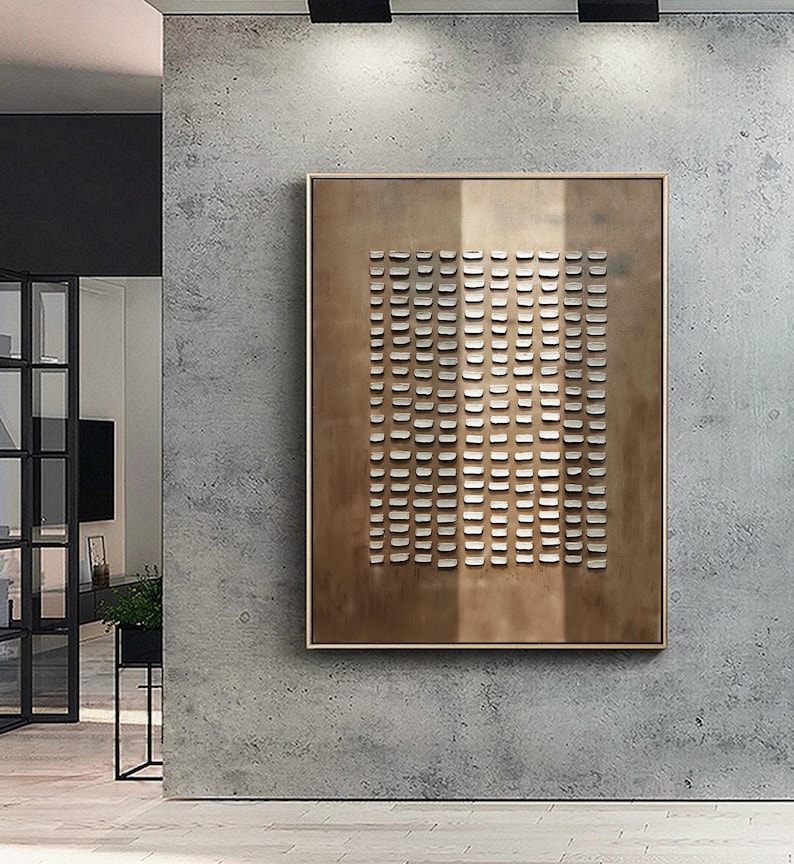 May include: A brown rectangular canvas with a grid of white squares. The canvas is hanging on a concrete wall.